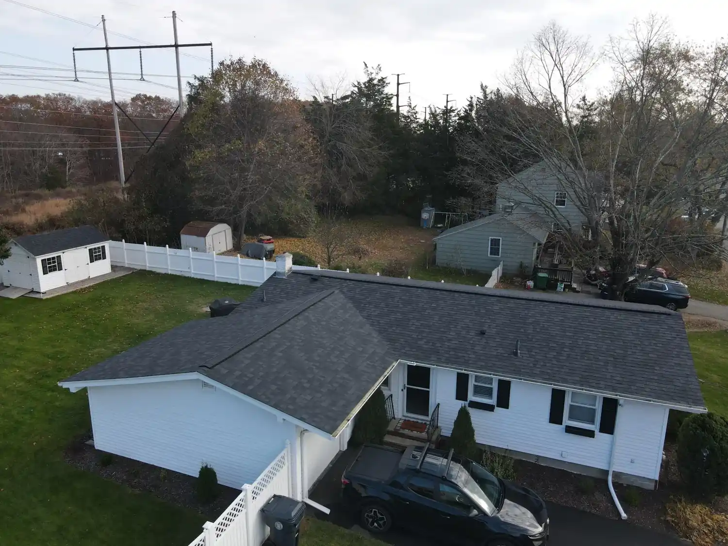 Aerial view of a completed asphalt shingle roof replacement by A&M Property Solutions on a Rhode Island home.
