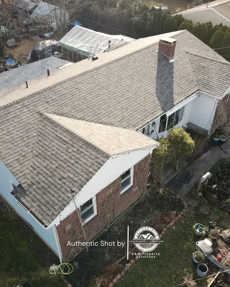 Newly installed architectural shingle roof on a Rhode Island home, photographed from above by A&M Property Solutions.